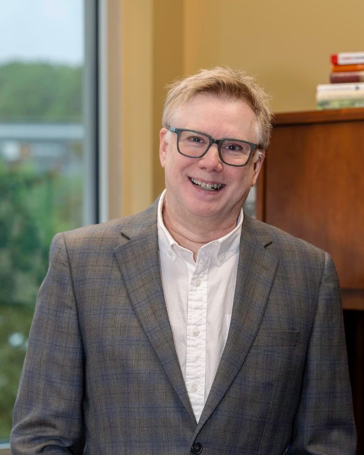 Brian Babyok smiling, hands in his pockets